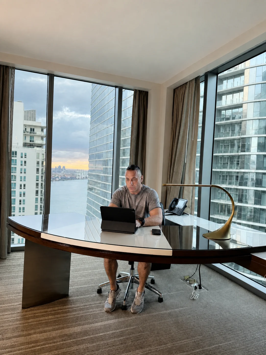 TPG founder David Price working from a high-rise office with a waterfront view